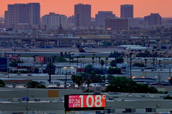  A sign displays a temperature as jets taxi at Phoenix Arizona's Sky Harbor International Airport at dusk on July 12, 2023.