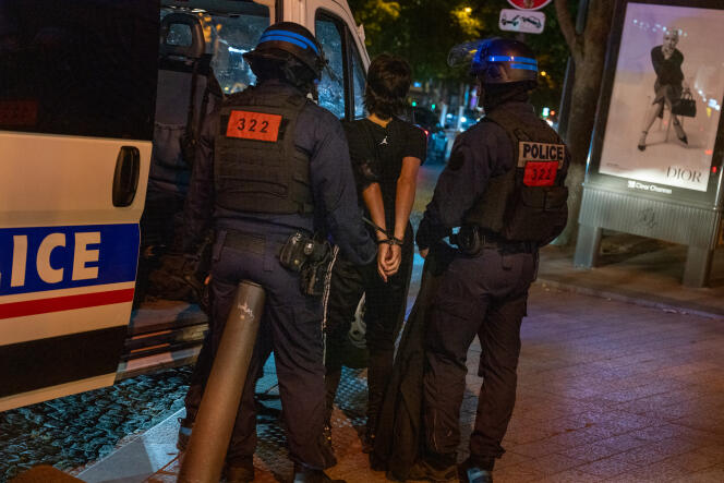 Un joven detenido por la policía en la avenida de los Campos Elíseos, en París, la noche del 1 al 2 de julio de 2023.