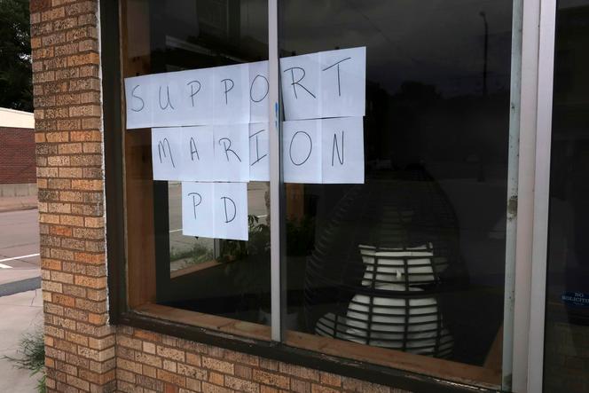 A storefront on the main street in downtown Marion, Kan., features a sign supporting the local police, Sunday, Aug. 13, 2023. 