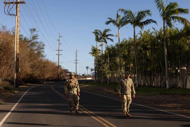 Members of the US National Guard stand on a closed road in Lahaina, west of Maui, Hawaii, August 12, 2023.
