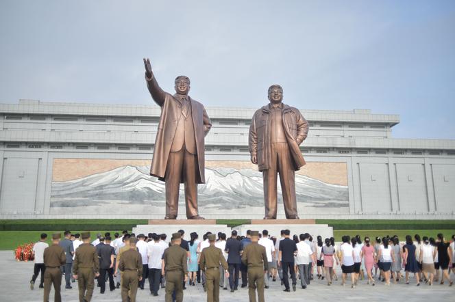 People pay their respects before the statues of late North Korean leaders Kim Il Sung and Kim Jong Il at Mansu Hill as North Korea marks its 78th National Liberation Day in Pyongyang on August 15, 2023.