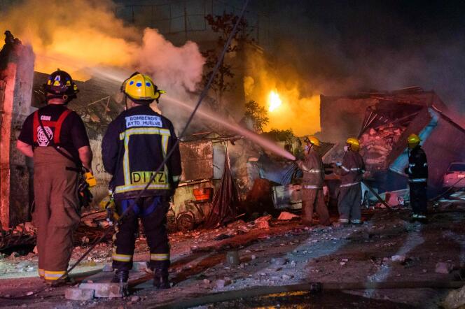 Los bomberos trabajan para apagar un incendio luego de una explosión en un establecimiento comercial en San Cristóbal, República Dominicana, el 14 de agosto de 2023.