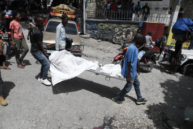 Morgue workers carry a body in the Carrefour-Feuilles neighborhood of Port-au-Prince, Haiti.  August 15, 2023.