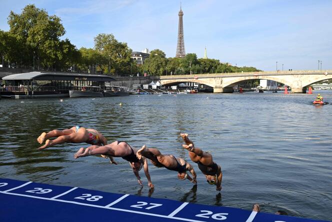 Los atletas se sumergen en las aguas del Sena en el puente Alexandre III, durante la prueba de familiarización con la natación en la víspera de una prueba de triatlón programada en París, el 16 de agosto de 2023.