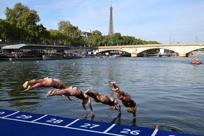 Athletes dive into the waters of the Seine at the Alexandre III bridge during the swimming familiarization test on the eve of a triathlon test scheduled in Paris on August 16, 2023.