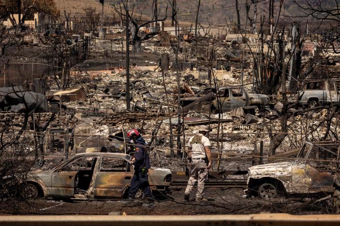Search and recovery team members check charred buildings and cars in the aftermath of the Maui Fires in Lahaina, Hawaii, August 17, 2023.