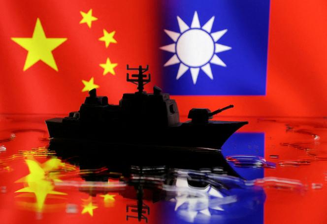 A Navy miniature is seen in front of displayed Chinese and Taiwanese flags in this illustration taken, April 11, 2023.