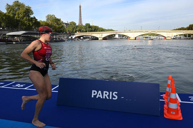 Un atleta se prepara para zambullirse en las aguas del Sena, en vísperas de las carreras de prueba de triatlón programadas en París, el 16 de agosto de 2023.