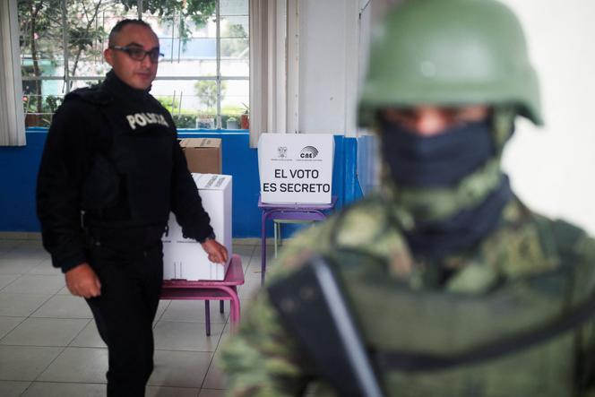 A solider and a police officer stand guard at a polling station on the day of a presidential election in Quito, Ecuador August 20, 2023. 