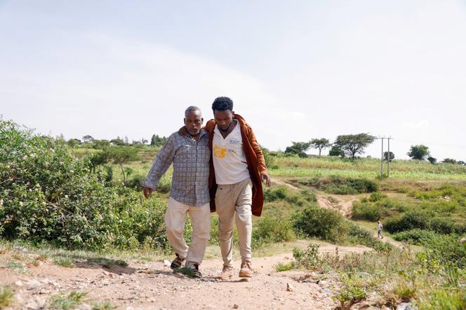 Mustafa Sofian, 22, an Ethiopian migrant who said he lost his left leg after the Saudi border guards fired at him, is helped up a hill by his father Sofian Mohamed, 48, after being repatriated by the International Organization for Migration (IOM) in Harar, Ethiopia, August 20, 2023.