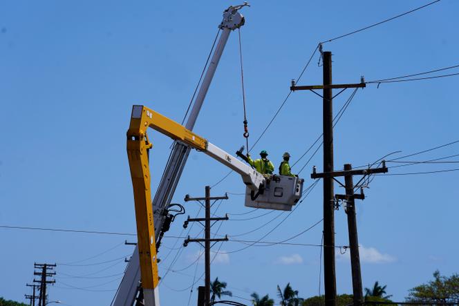 Linemen work, Sunday, August 13, 2023, in Lahaina, Hawaii, following a deadly wildfire that caused heavy damage days earlier.