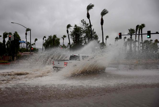 A vehicle drives through a flooded street from Tropical Storm Hilary on August 20, 2023, in Cathedral City, California.