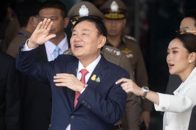Thailand's former Prime Minister Thaksin Shinawatra, left, with his daughter Paetongtarn, right, waves to his supporters as he arrives at Don Muang airport in Bangkok, Thailand, Tuesday, August 22, 2023.