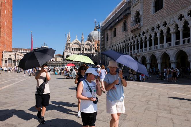 Tourists walk during a heatwave in Venice, Italy, on August 22, 2023. 