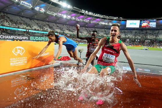 Gianmarco Tamberi, a sinistra, Soufiane El Bakkali, a destra, e Abraham Kibiwot, si tuffano nel fiume della corsa a ostacoli durante i Campionati del mondo di atletica leggera a Budapest, Ungheria, martedì 22 agosto 2023.