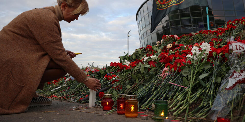 Une femme allume des bougies à un mémorial improvisé près des locaux du Groupe Wagner, à Saint-Pétersbourg, en Russie, le 24 août 2023.