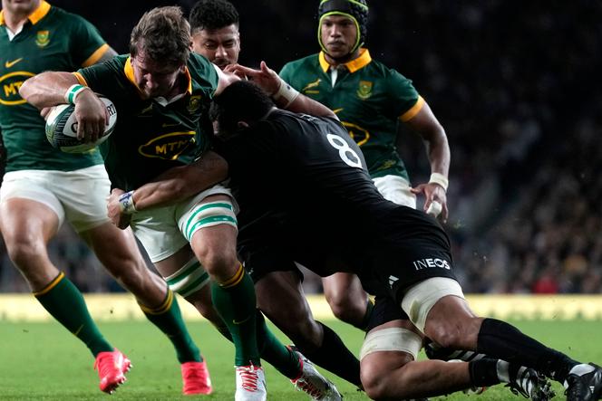South Africa's Kwagga Smith, center, scores a try as New Zealand's Ardie Savea tries to defend during the rugby union international match between South Africa and New Zealand, at Twickenham stadium in London, Friday, August 25, 2023.