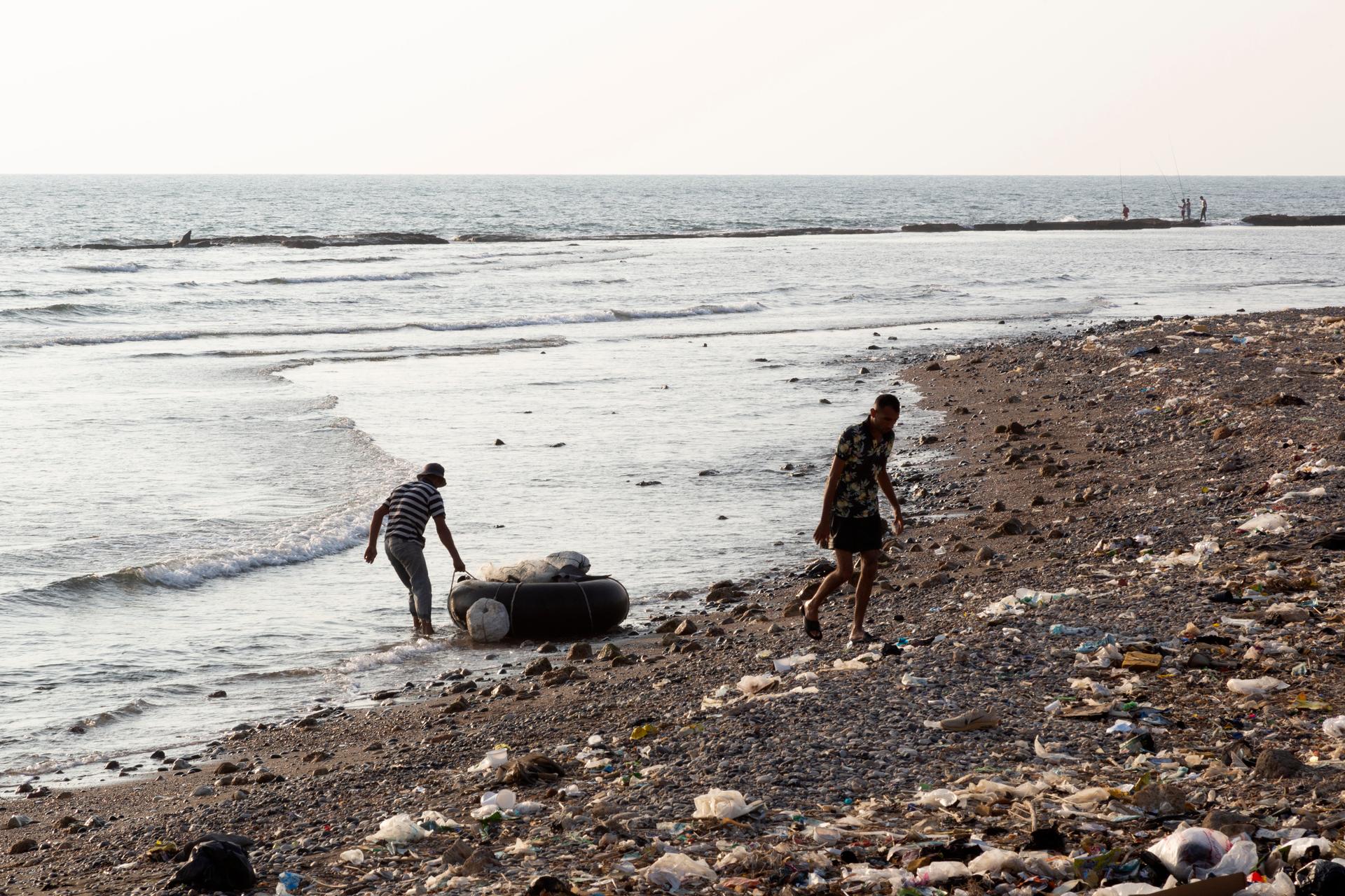 A man drags his boat, made from the inner tube of a tractor tire, in the village of Cheikh Zennad (Lebanon), on August 22, 2023.