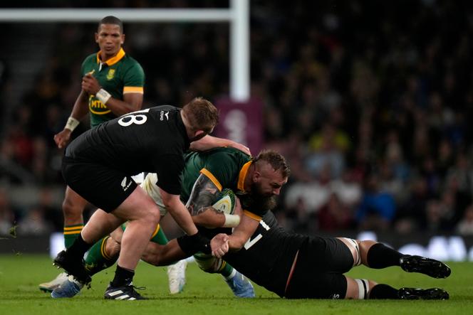 South Africa's RG Snyman, centre, is tackled by New Zealand's Fletcher Newell, left, and teammate Dalton Papali'i during the rugby union international match between South Africa and New Zealand, at Twickenham stadium in London, Friday, August 25, 2023.