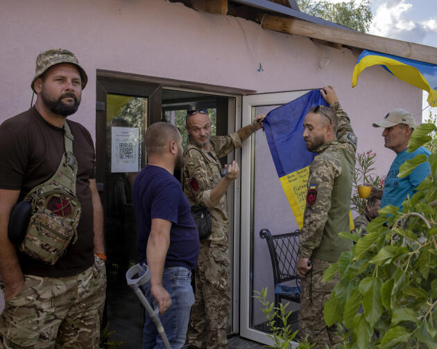Los soldados que regresan del frente firman la bandera durante la celebración del Día de la Bandera en Irbin, Ucrania, el 23 de agosto de 2023.