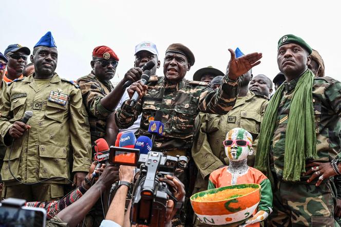 Niger's National Council for Safeguard of the Homeland (CNSP) leaders, Colonel Ibro Bachirou Amadou (C) speaks next to Colonel Amadou Djibo (L) and Niger's army artist Maman Sani Maigochi (R) at the general Seyni Kountche stadium in Niamey on Agust 26, 2023.