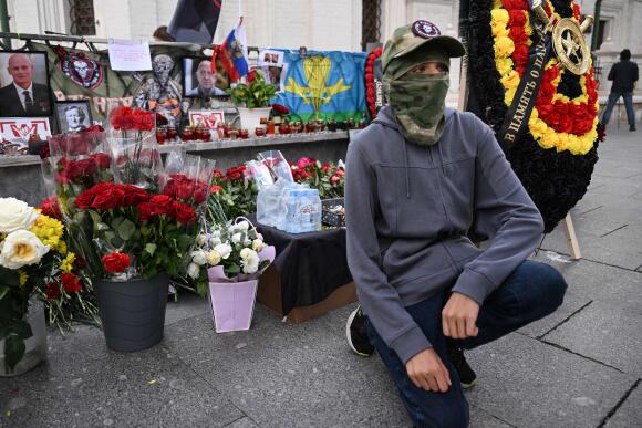 A young man kneels in front of a makeshift memorial to pay his respects to the head of the Wagner Group in Moscow on August 27, 2023.