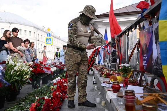 Un uomo indossa un cappello davanti a un monumento temporaneo eretto in memoria di Yevgeny Prigozhin, a Mosca il 27 agosto 2023.