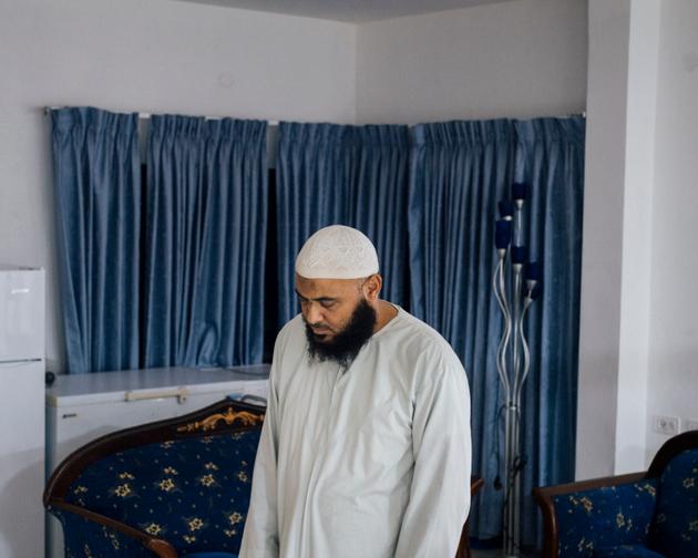 Mohammed Hujairat prays in the living room of his home in Bir al-Maksur on August 12, 2023.