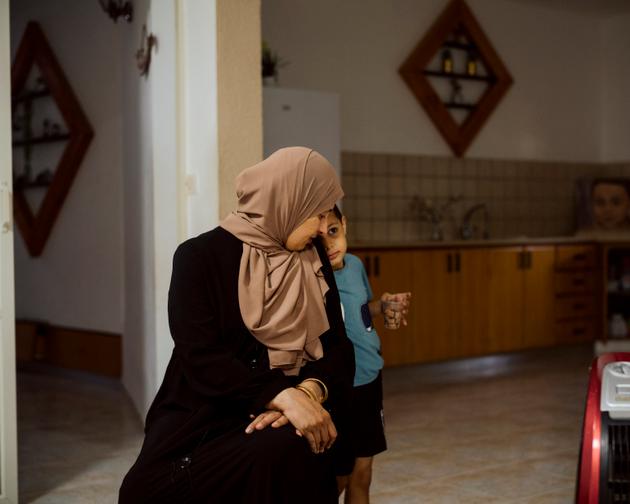 Aisha Hujairat and her second son Omar at home in Bir al-Maksur on August 12, 2023. 