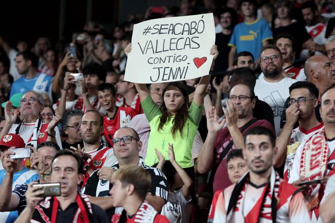 A girl holds a sign reading 'With you Jennié prior the Spanish Liga football match between Rayo Vallecano de Madrid and Club Atletico de Madrid at the Vallecas stadium in Madrid on August 28, 2023.