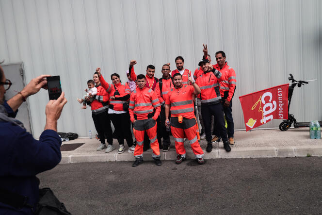 Dix des travailleurs qui occupent le centre de tri de Veolia, accompagnés du coordinateur CGT Ali Chaligui (derrière, en tee-shirt blanc), dans le 15e arrondissement de Paris, le 28  août 2023.