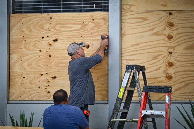 People board up a window in Tampa, Florida, on August 29, 2023, as the city prepares for Hurricane Idalia.