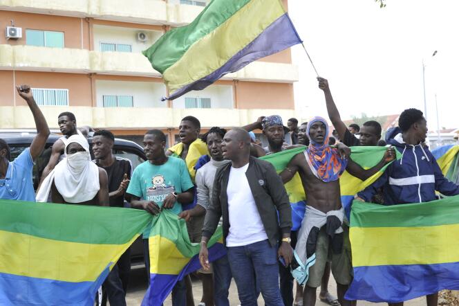 Los residentes ondean la bandera nacional de Gabón en Libreville el 30 de agosto de 2023.