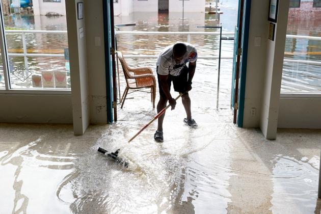 Donnye Franklin helps a friend clear water from his Explorer Manatee Tour store in Crystal River, Florida, on August 30, 2023.