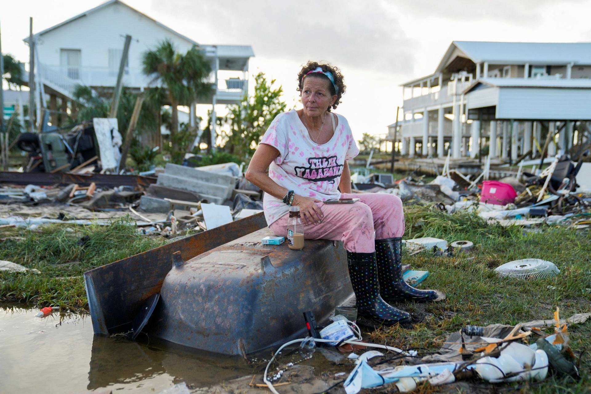 Jewell Baggett, 51, on a bathtub amid the rubble of the house built by her grandfather in Horseshoe Beach, Florida. She grew up there and three generations of her family lived in the home. August 30, 2023.