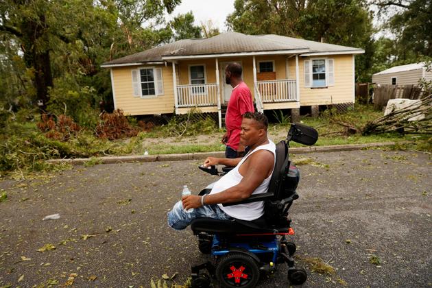 People look on as fallen branches lie on the ground after the arrival of Hurricane Idalia, in Perry, Florida, US, August 30, 2023.