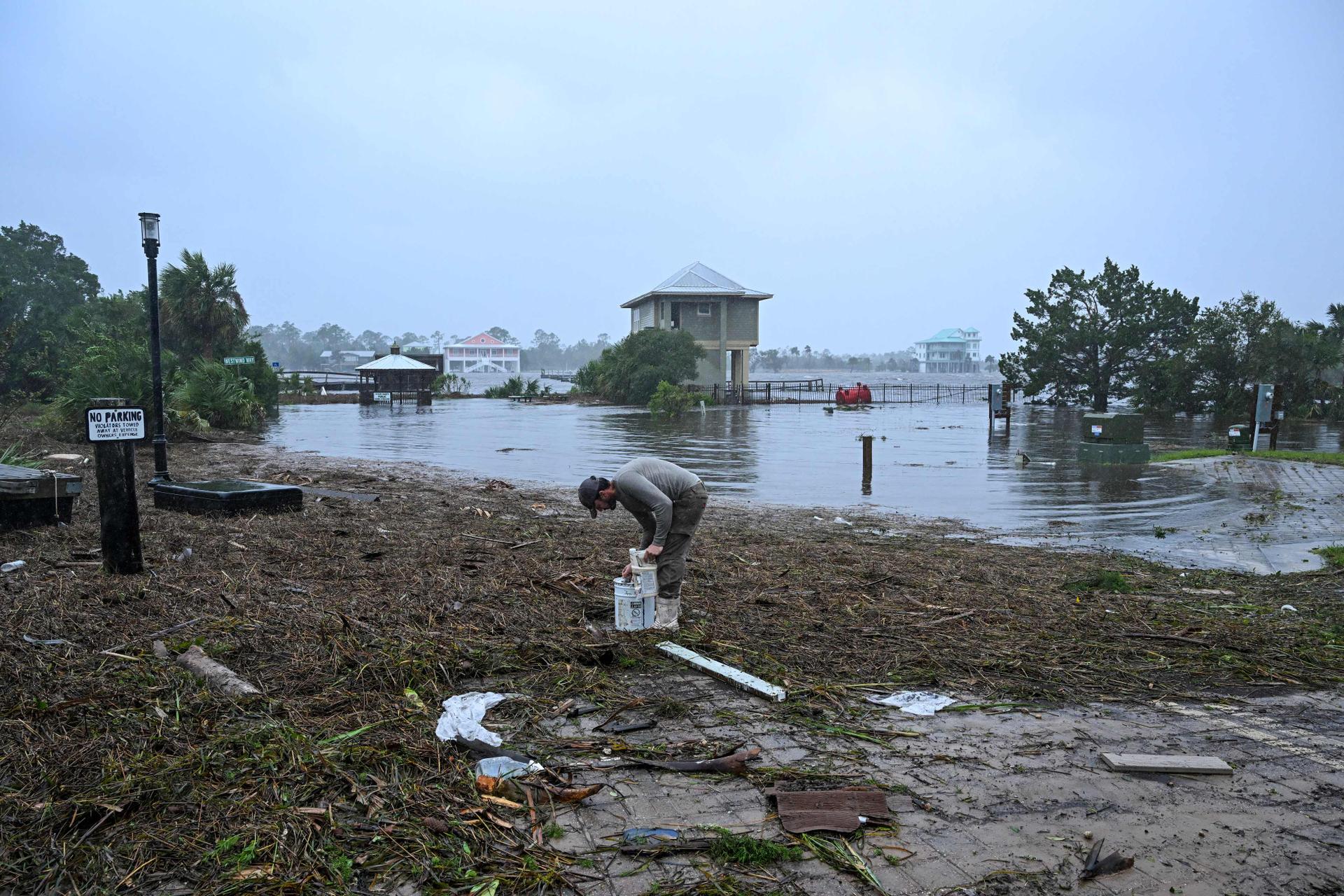 Resident Bobby Adisano picks up his belongings near Florida's Steinhatchee Marina on August 30, 2023.