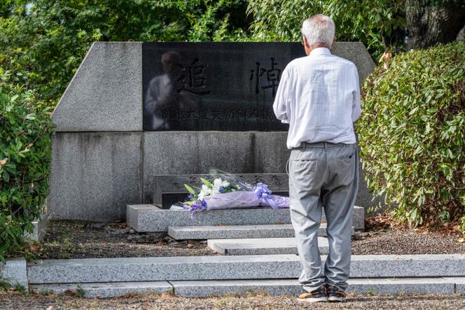 A man prays at a monument dedicated to Koreans who were massacred following the September 1, 1923 earthquake, which killed over 100,000 people in the destruction and resulting fires across Tokyo.