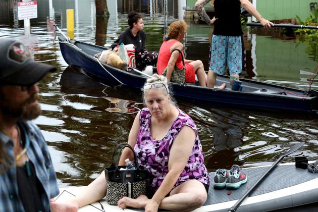 Residents of Twin City Mobile Home Park, a subdivision of prefabricated homes, navigate through the flooded neighborhood, in St. Petersburg, Florida, on August 30, 2023.