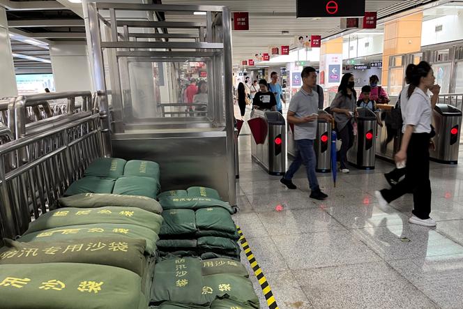 Commuters walk past sandbags at a subway station as Super Typhoon Saola approaches, in Shenzhen, Guangdong province, China September 1, 2023. 