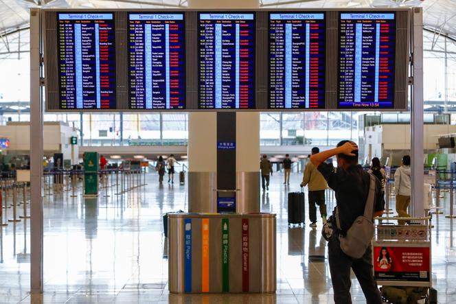 A passenger looks at an information display showing almost all of the flights have been canceled due to the super typhoon Saola, at Hong Kong International Airport, on September 1, 2023. 