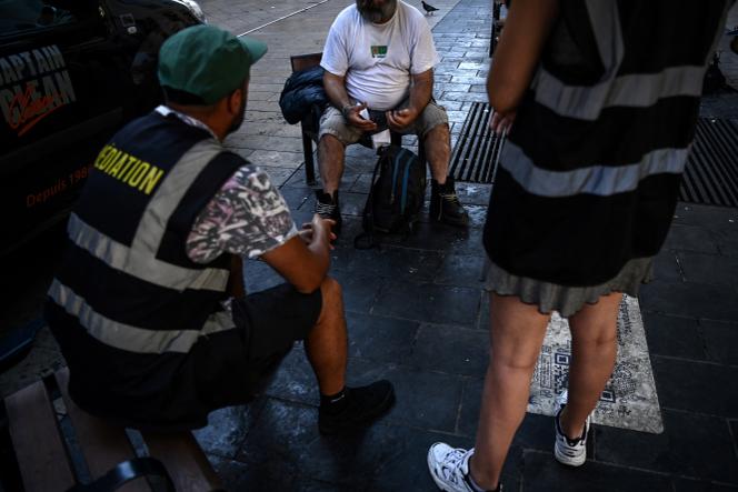 Un sans-abri et des travailleurs sociaux, à Bordeaux, le 24 août 2023.