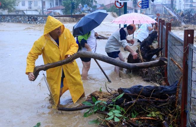 Residents remove debris from a flooded area in the town of Volos, central Greece, Tuesday, September 5, 2023. 