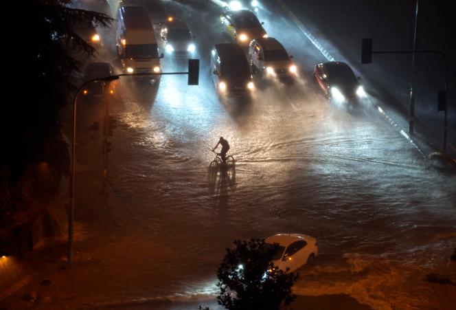 A cyclist rides through floodwater blocking the road due to heavy rain in Basaksehir district of Istanbul, Turkey, Tuesday, September 5, 2023.