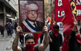 A man holding a picture of Chile's late President Salvador Allende takes part in a demonstration marking the 50th anniversary of a military coup led Gen. Augusto Pinochet in Santiago, Chile, Sunday, Sept. 10, 2023. Allende was killed during the coup. (AP Photo/Matias Basualdo)