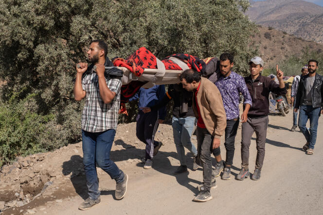 Un blessé originaire d’un village isolé dans la montagne est porté afin d’être pris en charge par une ambulance, dans la province d’Al-Haouz, le 12 septembre 2023.