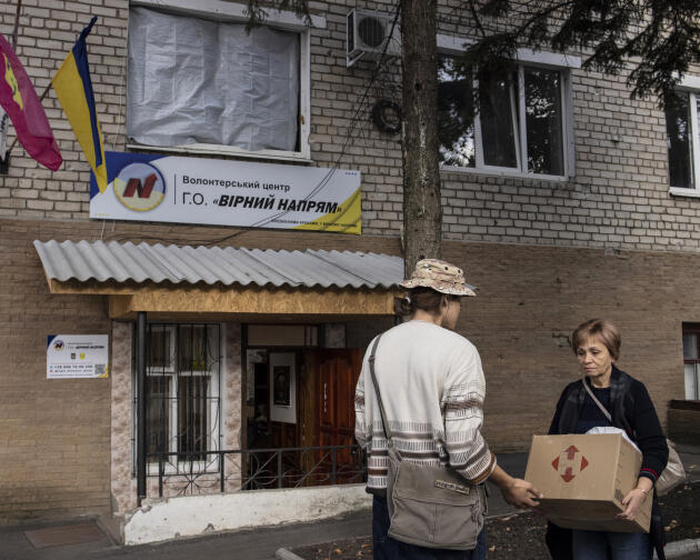Un volontaire aide une Ukrainienne devant le centre humanitaire public d’Izioum (Ukraine), le 12 septembre 2023. Ouvert depuis la libération de la ville en septembre 2022, le lieu propose également des services d’aide et d’accompagnement à la personne.