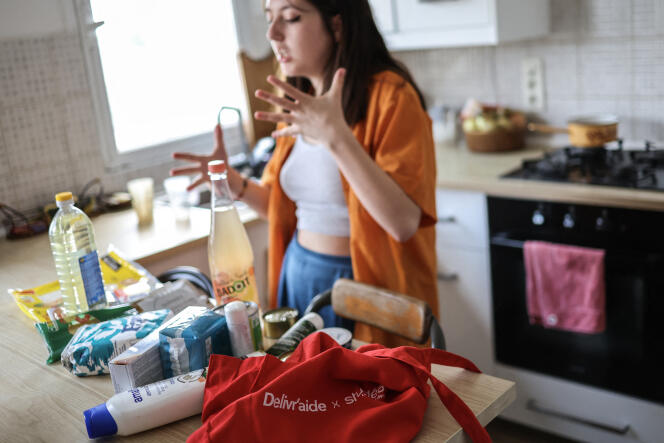 Une étudiante devant un sac de produits alimentaires et d’hygiène qu’elle a reçu de l’association Delivr’aide, à Toulouse, le 10 mai 2023.