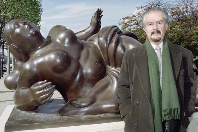 Colombian sculptor Fernando Botero poses in front of one of his works on the Champs Elysées avenue in Paris on October 16, 1992. 