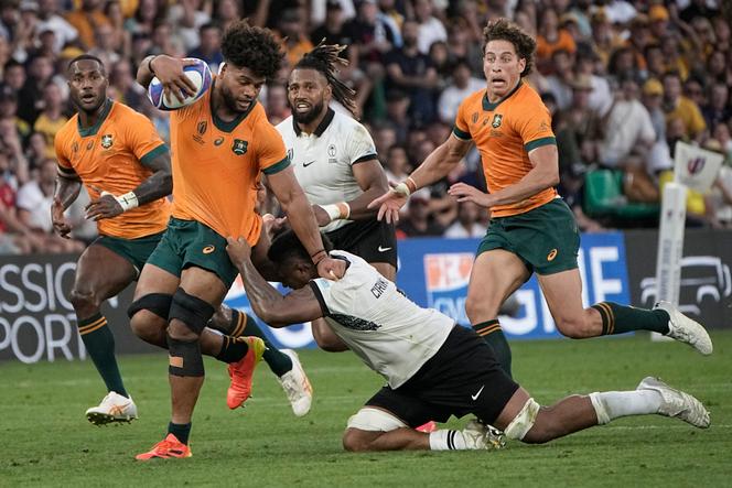 Australia's Rob Valetini, second from left, runs with the ball against Fiji's Te Ahiwaru Cirikidaveta during the Rugby World Cup Pool C match between Australia and Fiji at the Stade Geoffroy Guichard in Saint-Etienne, France, Sunday, September 17, 2023.